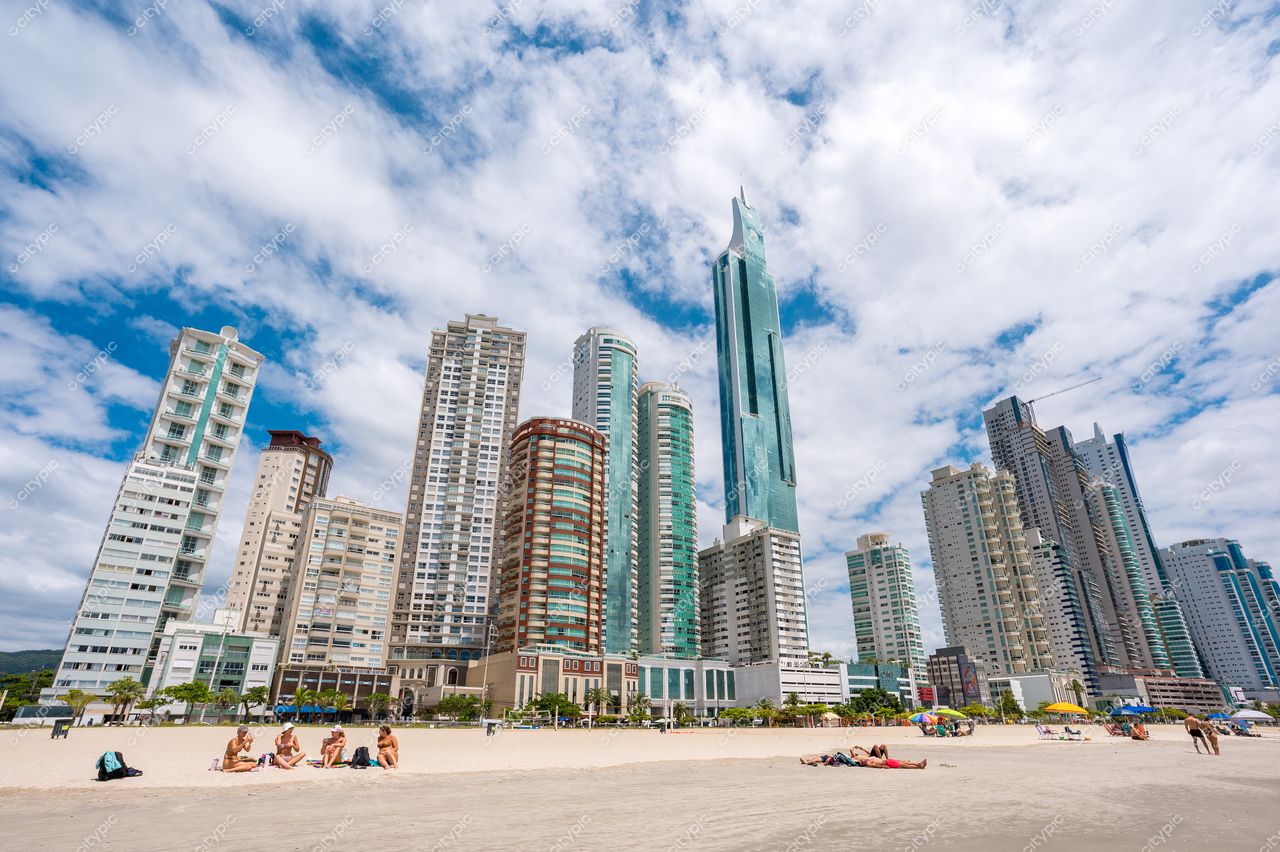 Balneário Camboriú, Santa Catarina, vista da orla com edifícios altos e pessoas na areia em dia ensolarado