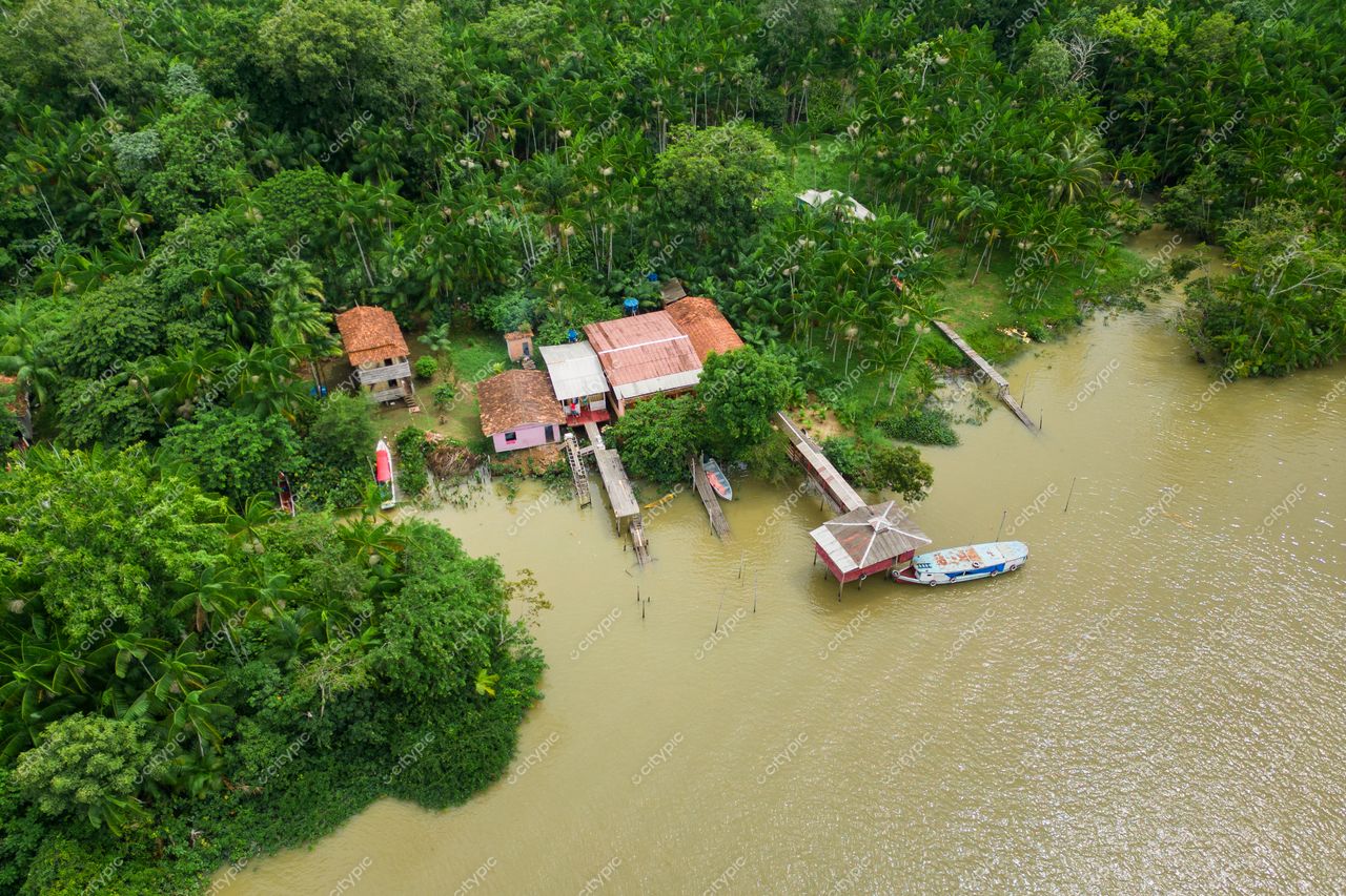Belém, Pará vista aérea de área rural com casas simples, palafitas e vegetação densa à beira d’água