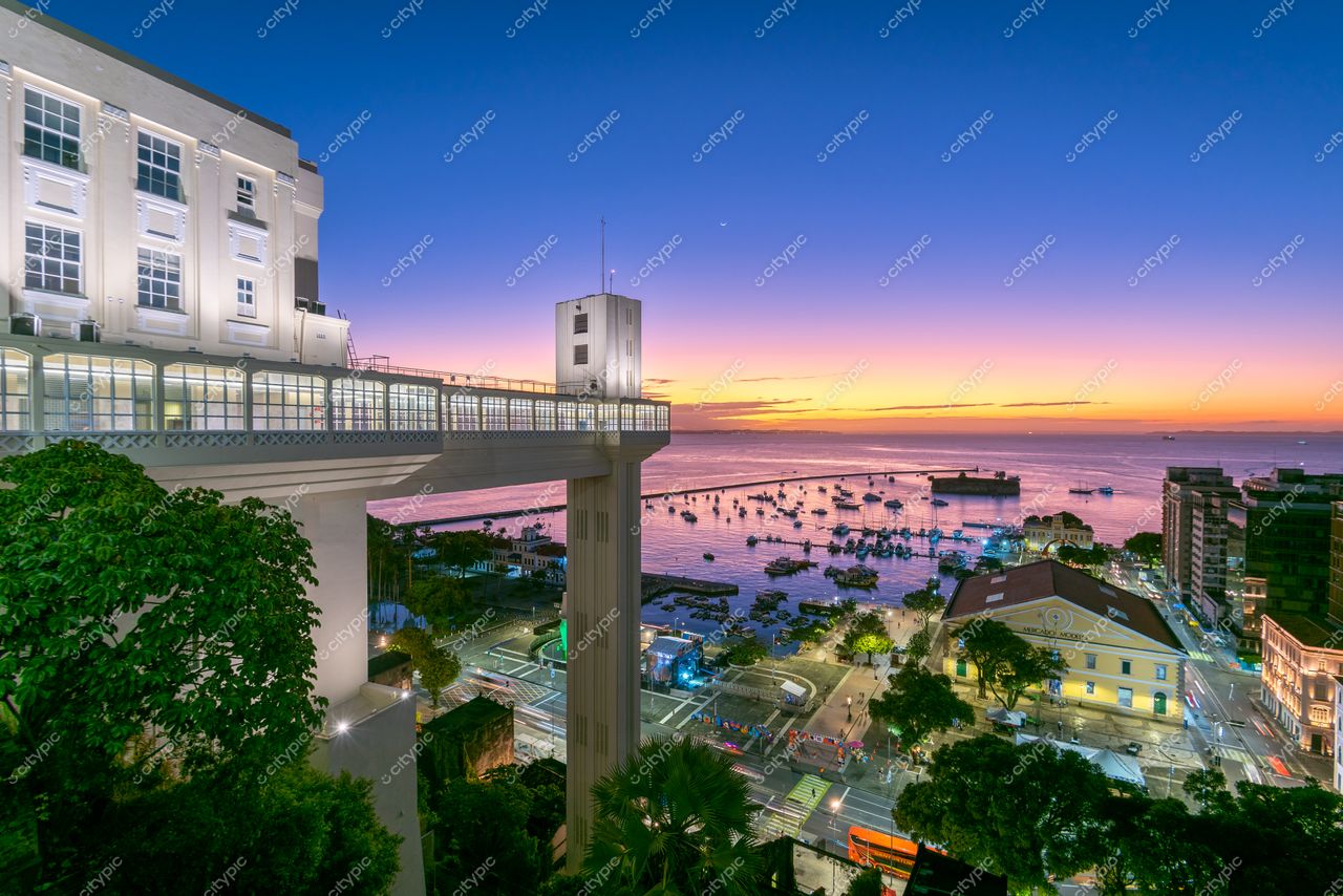 Salvador, Bahia, panorama ao crepúsculo com arquitetura moderna, baía com barcos e vegetação urbana iluminada
