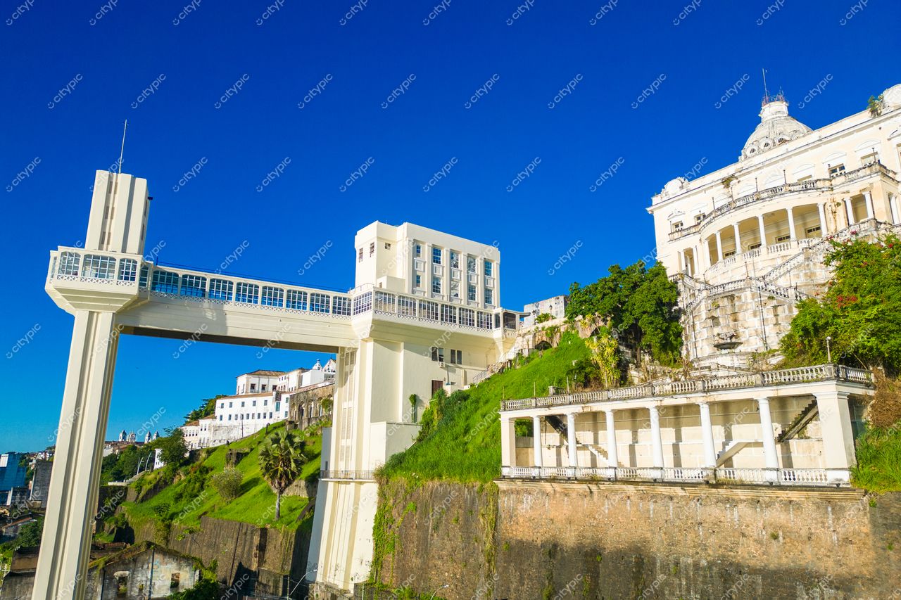 Salvador, Bahia, Elevador Lacerda em destaque com céu azul, vegetação ao redor e arquitetura clássica ao fundo