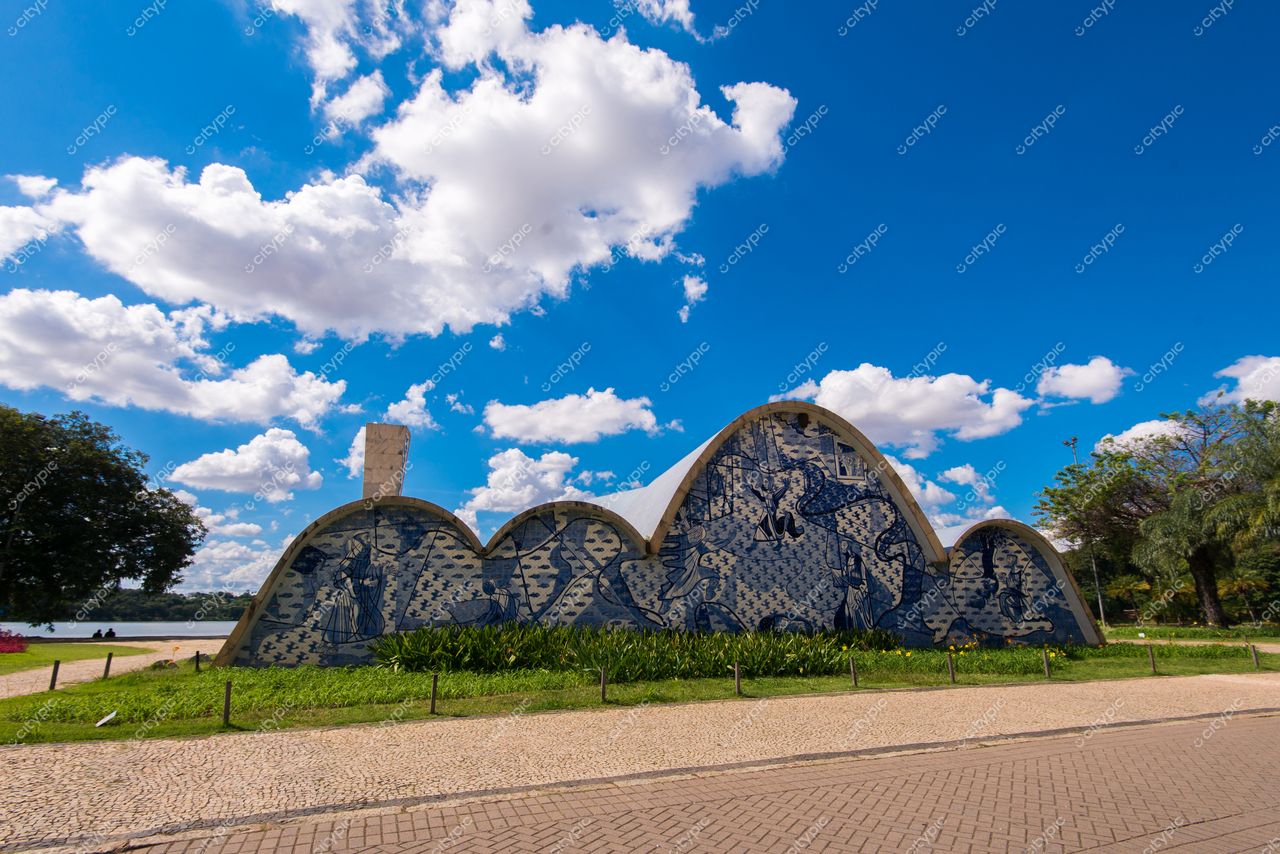 Belo Horizonte, Minas Gerais, edifício em forma de ondas com mosaicos azuis e brancos sob céu claro e vegetação exuberante