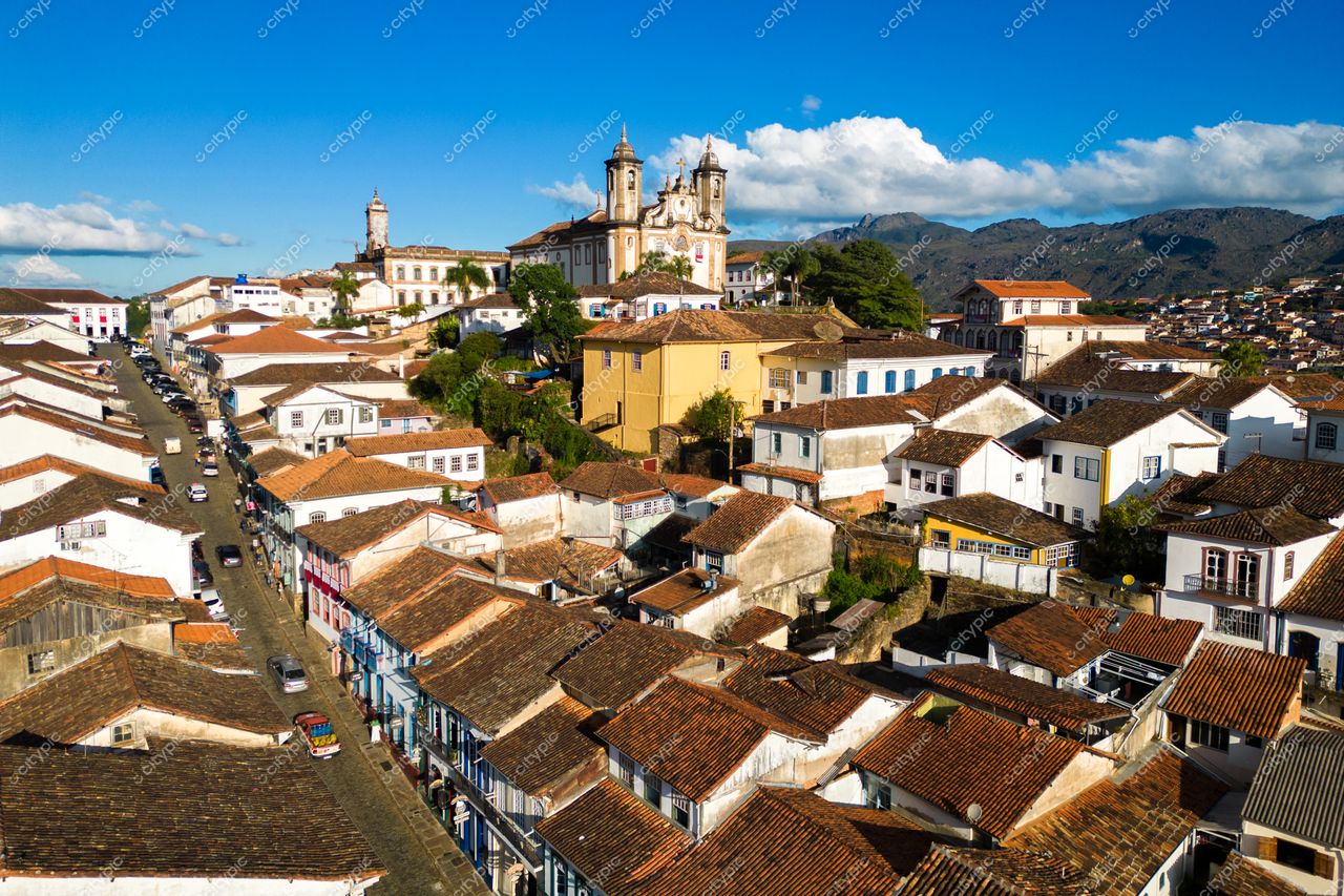 Ouro Preto, Minas Gerais com vista panorâmica das construções coloniais e relevo montanhoso sob céu claro e iluminação natural