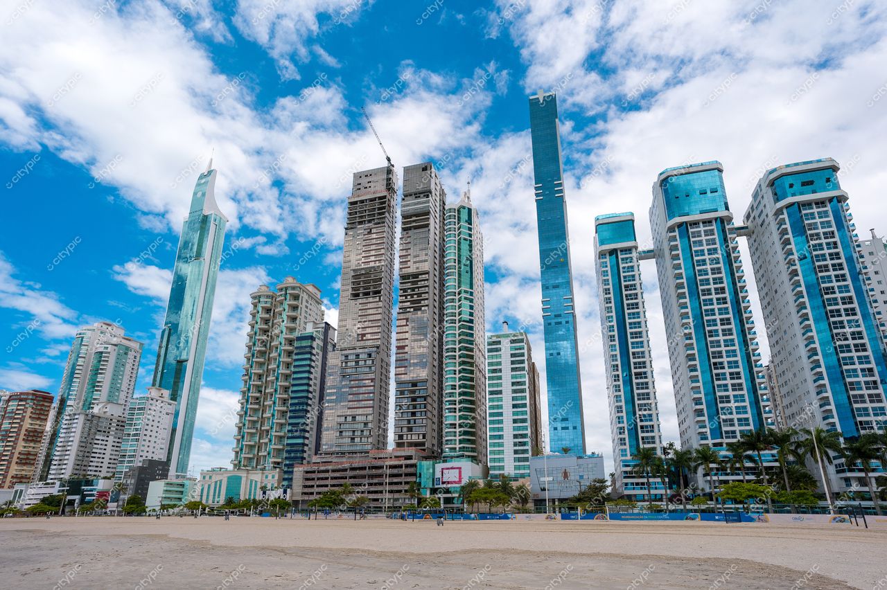 Balneário Camboriú, Santa Catarina, skyline moderna com arranha-céus em construção sob céu nublado e praia tranquila