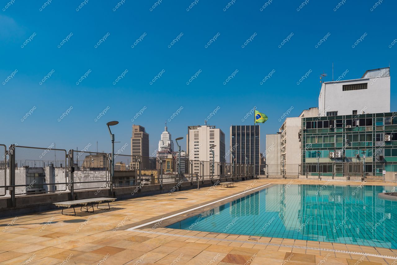 São Paulo, São Paulo, vista panorâmica de rooftop com piscina refletindo céu azul e edifícios altos ao fundo