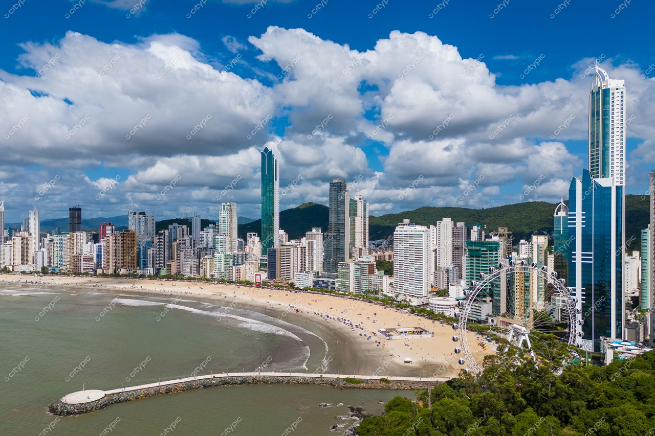 Balneário Camboriú, Santa Catarina, skyline com arranha-céus modernos e praia clara sob céu azul e nuvens brancas