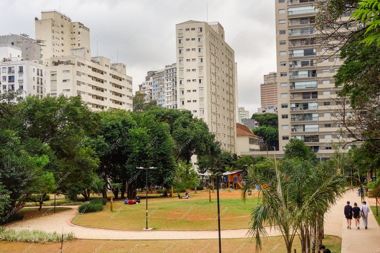 Parque Tenente Siqueira Campos (Trianon) em São Paulo com céu nublado e pessoas caminhando entre árvores e edifícios altos