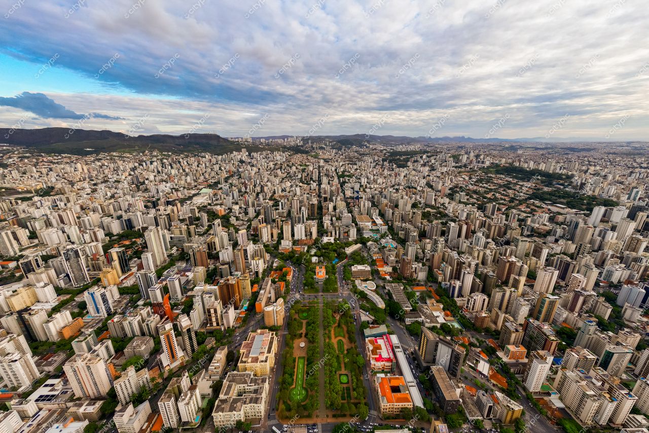 Belo Horizonte, Minas Gerais vista aérea com densa urbanização e áreas verdes sob céu com nuvens dispersas