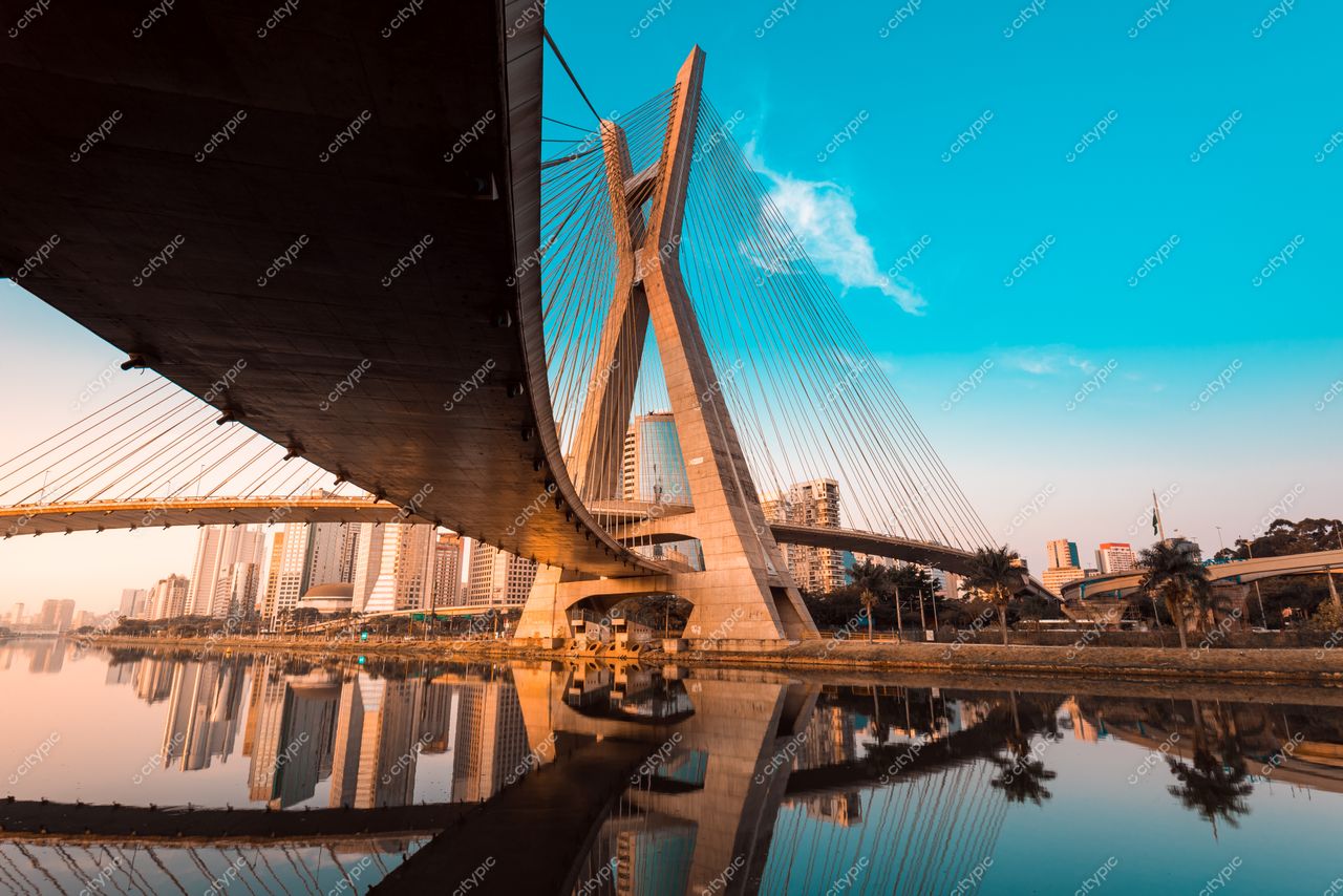 São Paulo, São Paulo, ponte Estaiada ao pôr do sol com reflexos na água e ausência de tráfego urbano