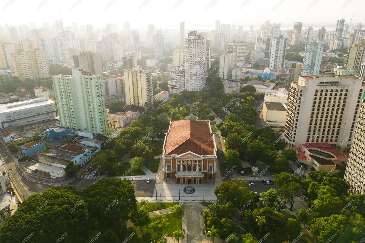 Belém, Pará vista aérea com Theatro da Paz em destaque e vegetação ao redor em iluminação suave do amanhecer