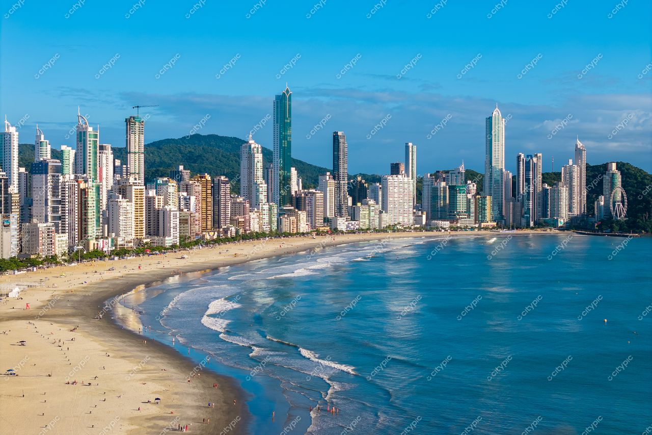 Balneário Camboriú, Santa Catarina, vista panorâmica da orla em dia ensolarado com arranha-céus e vegetação montanhosa