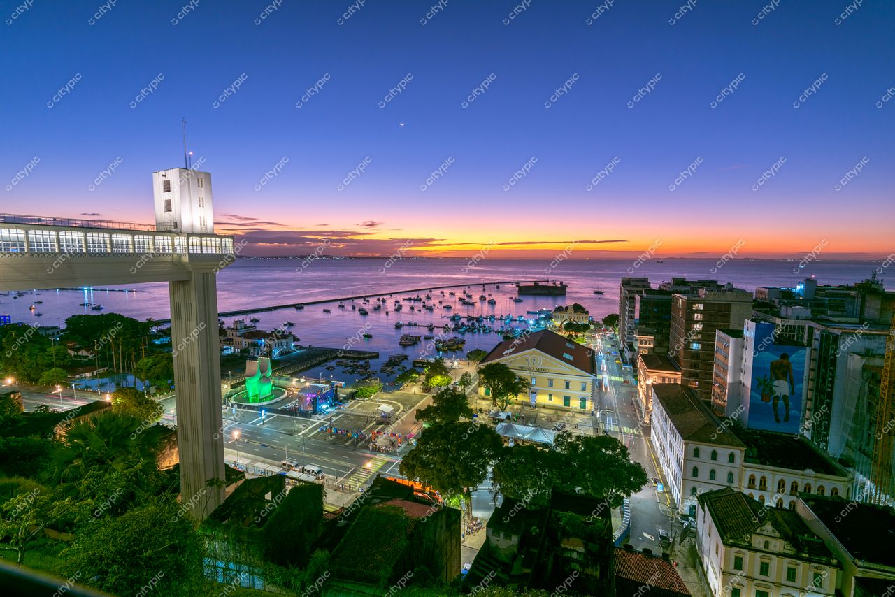Salvador, Bahia vista panorâmica do Elevador Lacerda ao crepúsculo com céu laranja e azul refletido na baía