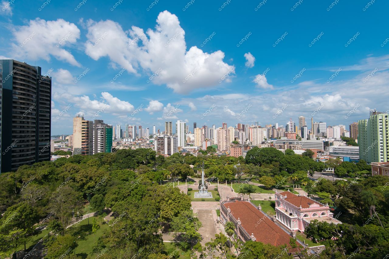 Belém, Pará com céu azul e nuvens brancas sobre área verde e edifícios altos em dia ensolarado