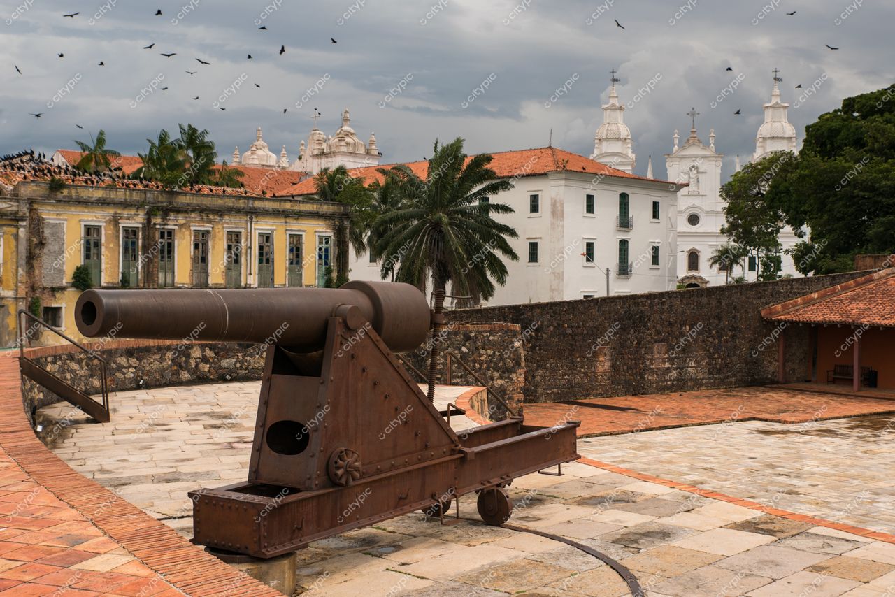 Belém, Pará, canhão de ferro em área histórica com arquitetura colonial e vegetação tropical sob céu nublado