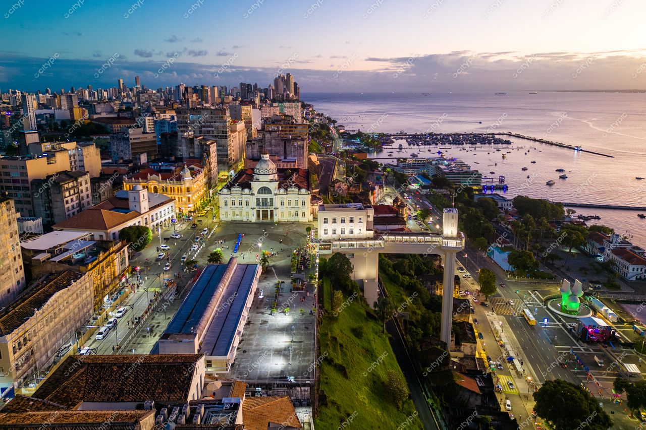 Salvador, Bahia ao amanhecer com vista panorâmica de edifícios históricos e modernos e vegetação urbana entrelaçada