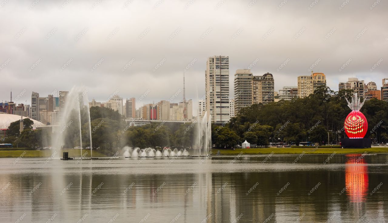 São Paulo, São Paulo, lago refletindo edifícios icônicos com fontes d’água e vegetação sob céu nublado