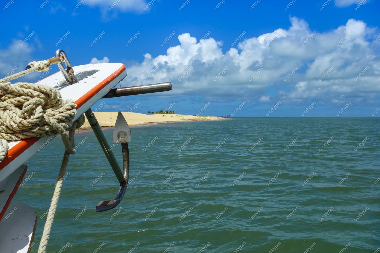 Brejo Grande, Sergipe barco ancorado em águas calmas com cordas visíveis e faixa de areia ao fundo
