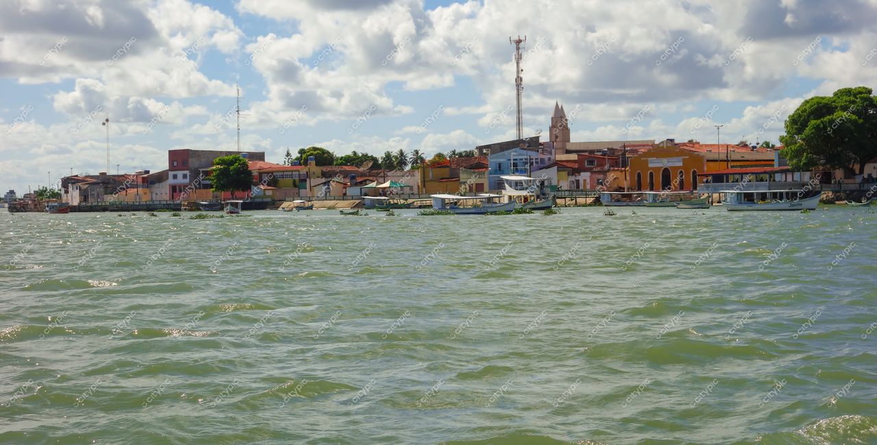 Brejo Grande, Sergipe com vista do rio e construções coloridas à margem em dia ensolarado e céu claro
