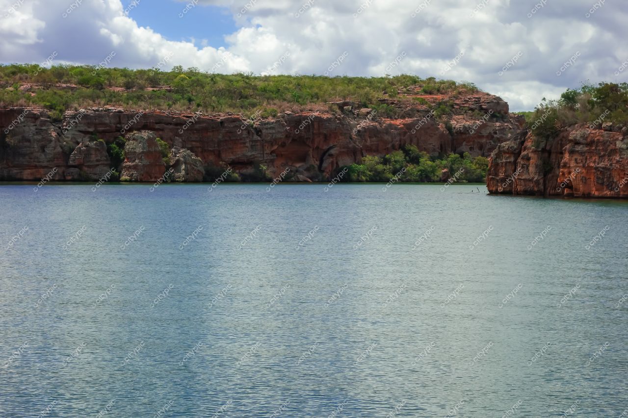 Canindé de São Francisco, Sergipe, paisagem serena com água refletindo céu azul e formações rochosas avermelhadas