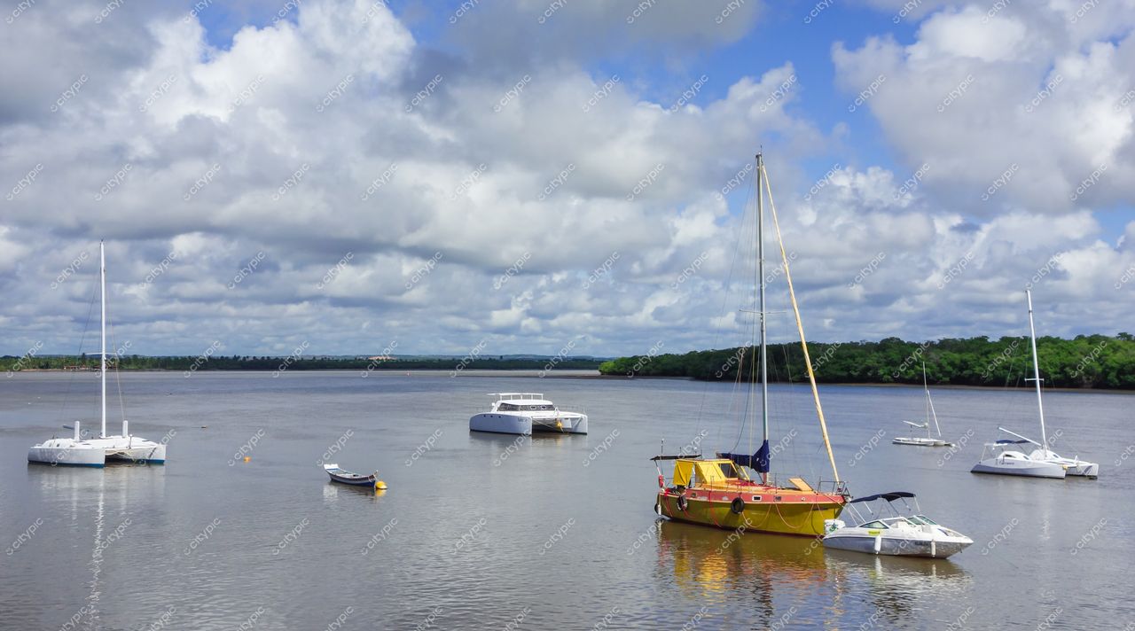 Aracaju, Sergipe, cenário tranquilo à beira do rio com barcos ancorados e vegetação preservada em dia ensolarado
