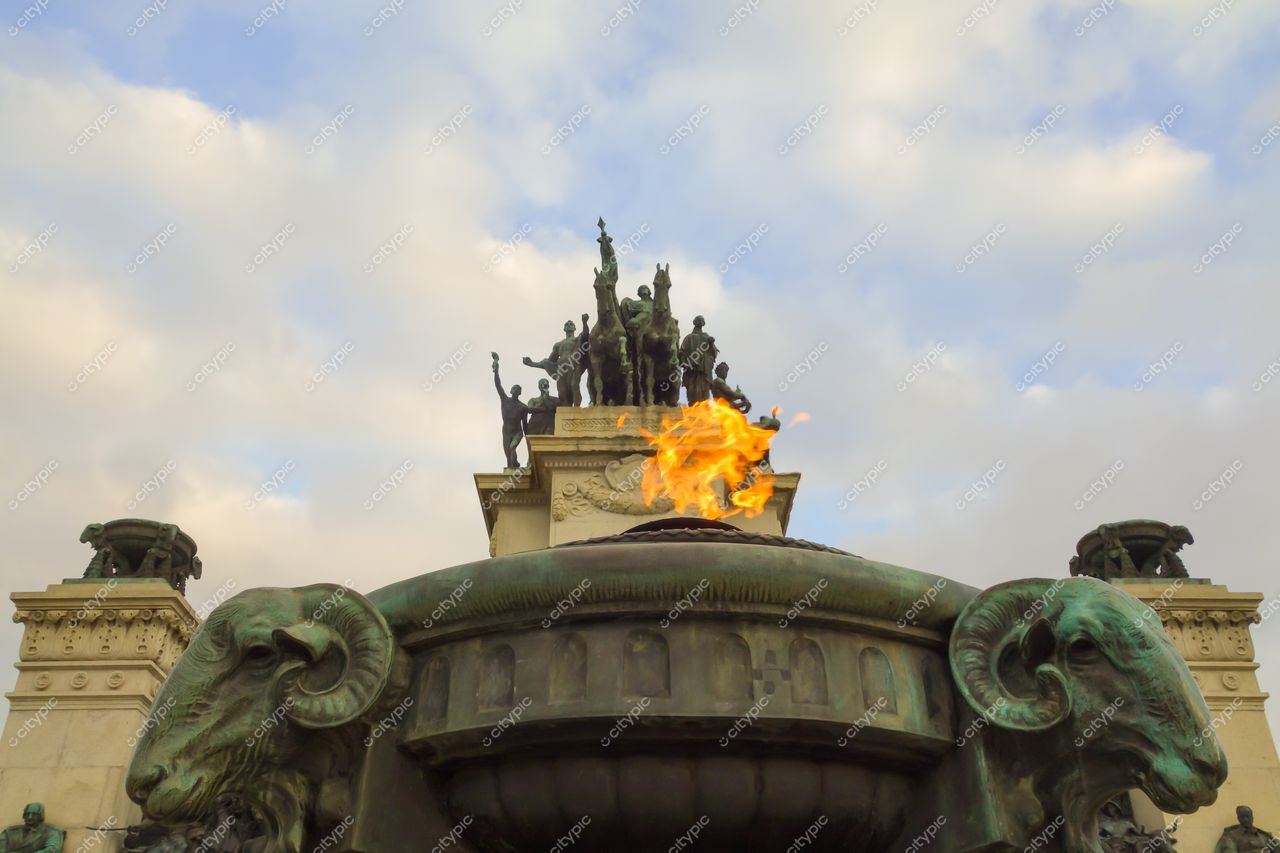 São Paulo, São Paulo, monumento com chama central em fonte e esculturas de carneiros sob céu nublado ao entardecer