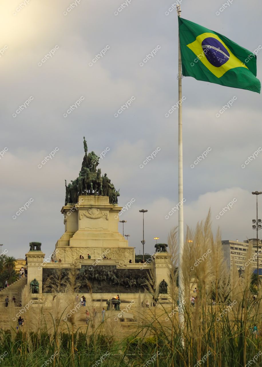 São Paulo, São Paulo, monumento imponente com estátua e bandeira do Brasil ao vento em iluminação de final de tarde