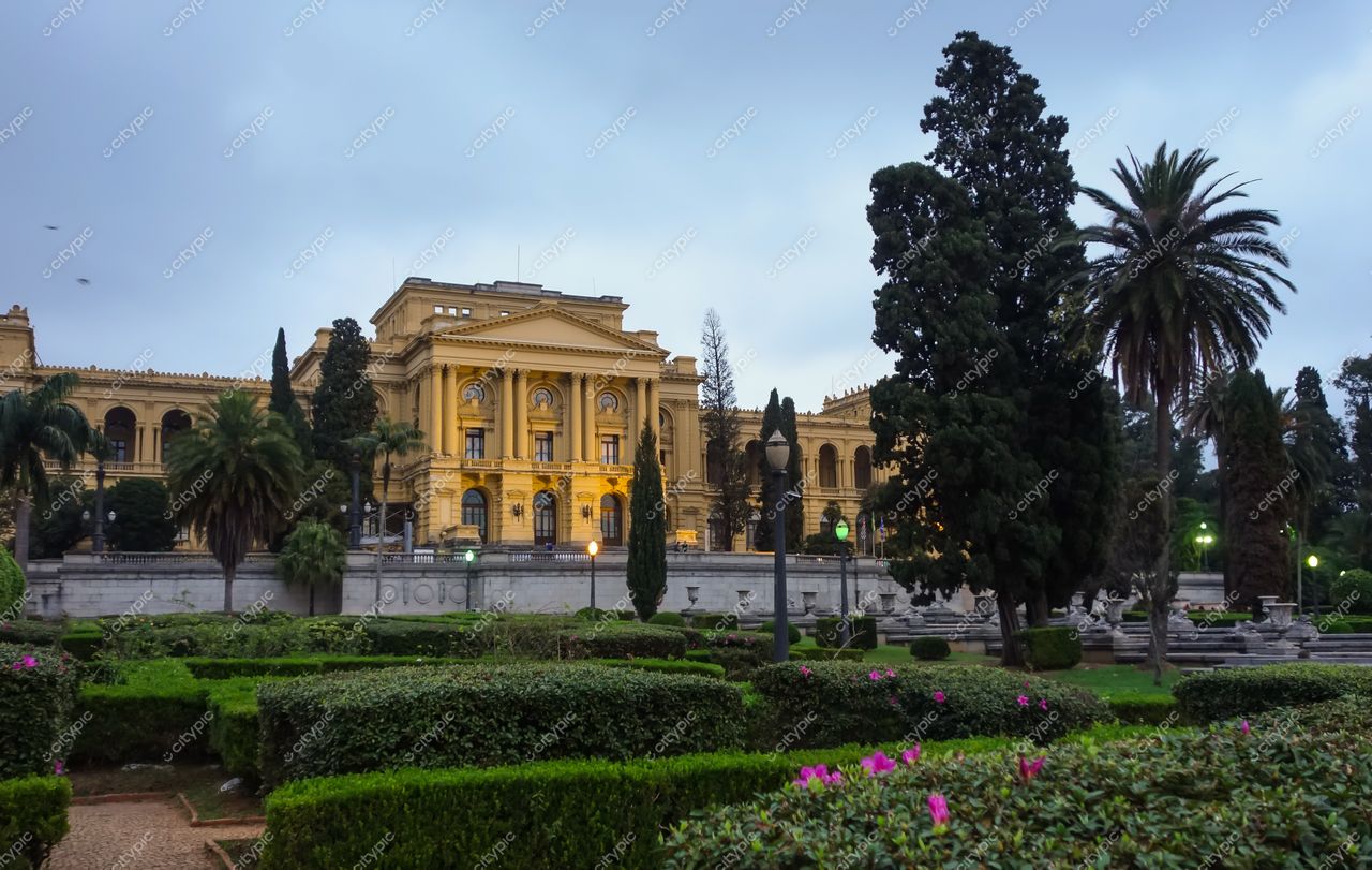 São Paulo, São Paulo, edifício histórico neoclássico amarelo com jardim bem cuidado e céu nublado ao entardecer