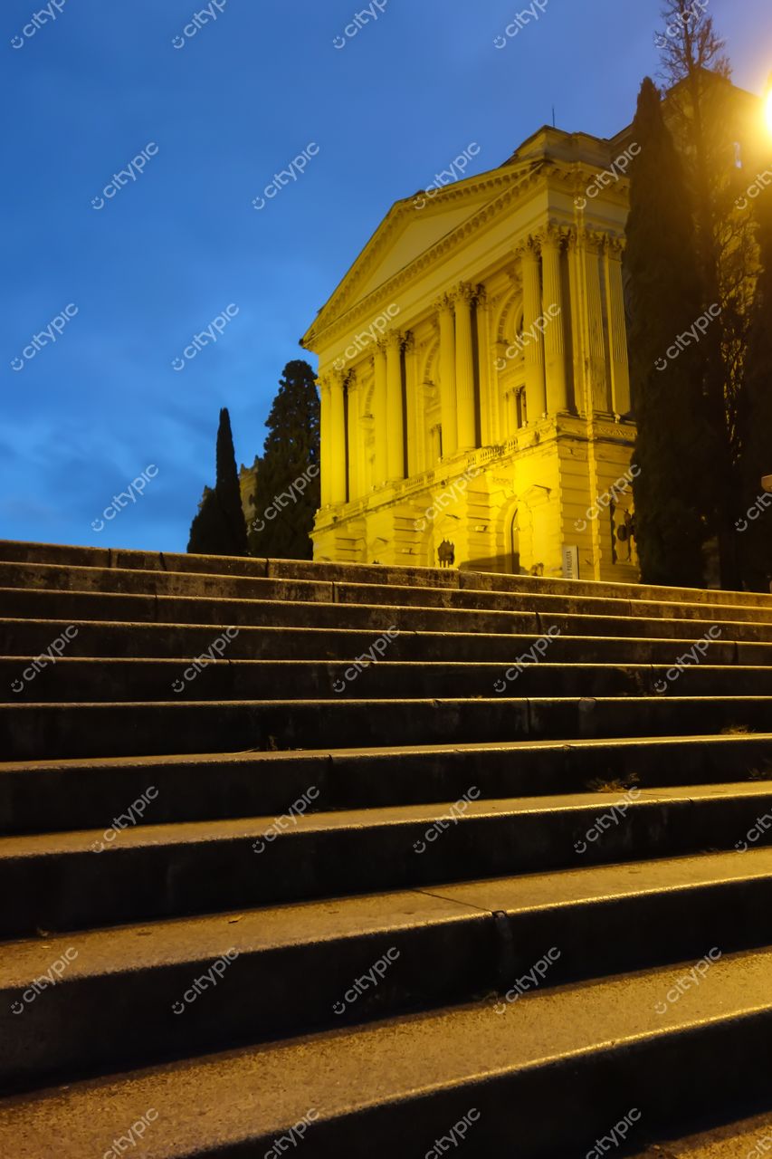 São Paulo, São Paulo, escadaria de pedra com edifício amarelo ao crepúsculo e árvores escuras ao redor