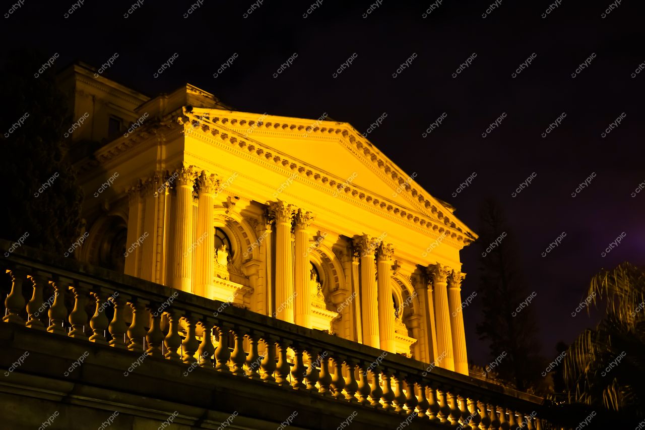 São Paulo, São Paulo, edifício histórico iluminado em tom dourado com colunas clássicas e vegetação ao redor à noite