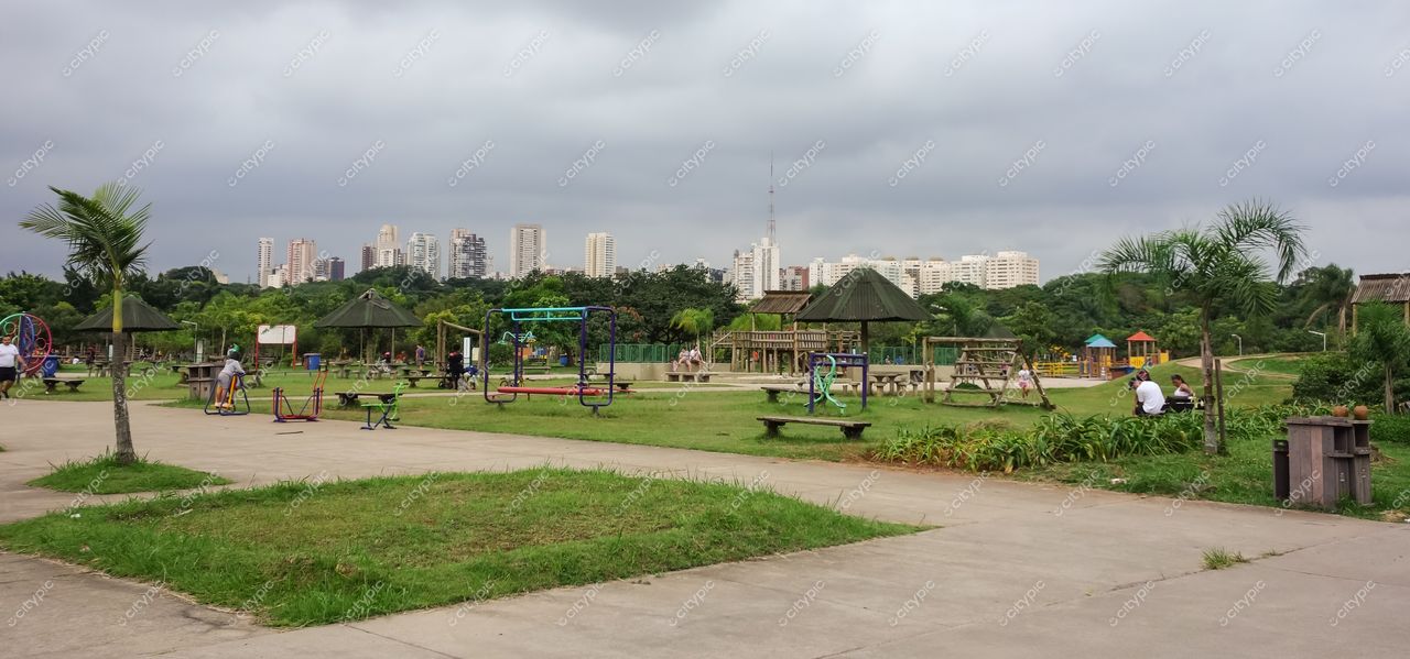 São Paulo, São Paulo, parque com áreas verdes e equipamentos de lazer sob céu nublado e prédios ao fundo
