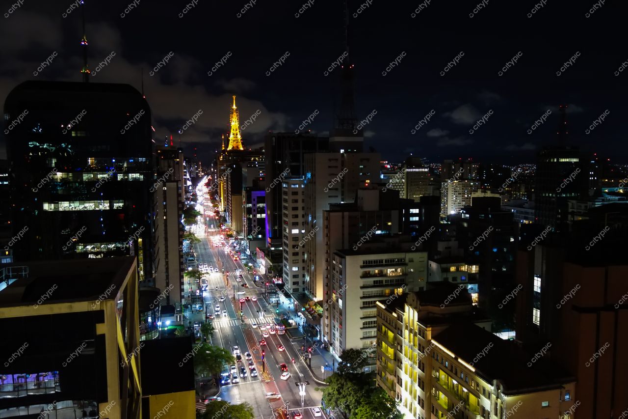 São Paulo, São Paulo, vista noturna com a Torre Eiffel iluminada em amarelo e tráfego intenso nas ruas