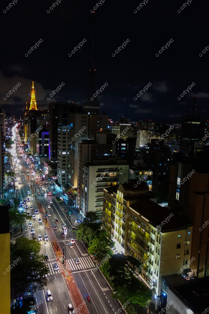 São Paulo, São Paulo, horizonte noturno com torre iluminada em âmbar e tráfego intenso nas ruas movimentadas