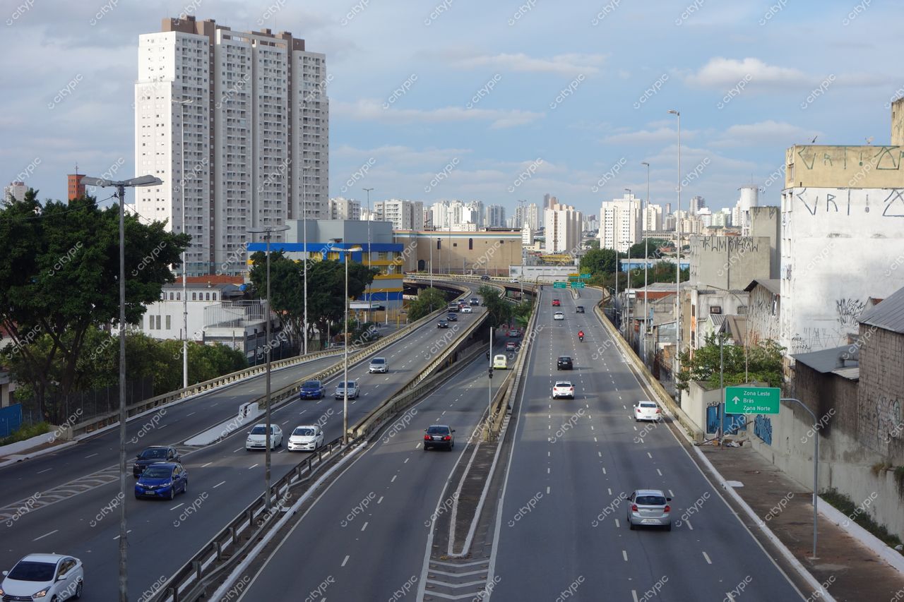 São Paulo, São Paulo, vista urbana com via expressa, edifícios modernos e vegetação à esquerda sob céu nublado