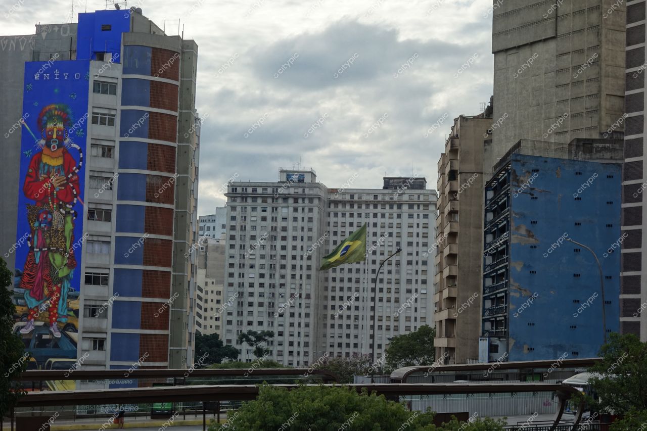São Paulo, São Paulo com mural colorido em prédio, céu nublado e vegetação na parte inferior da imagem