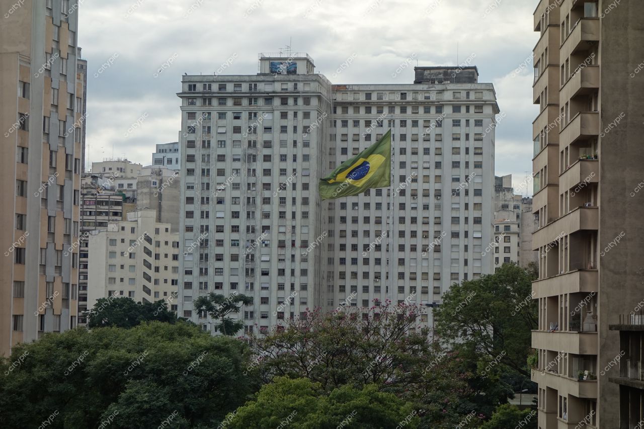 São Paulo, São Paulo, vista urbana com grande edifício e bandeira do Brasil em dia nublado e tranquilo