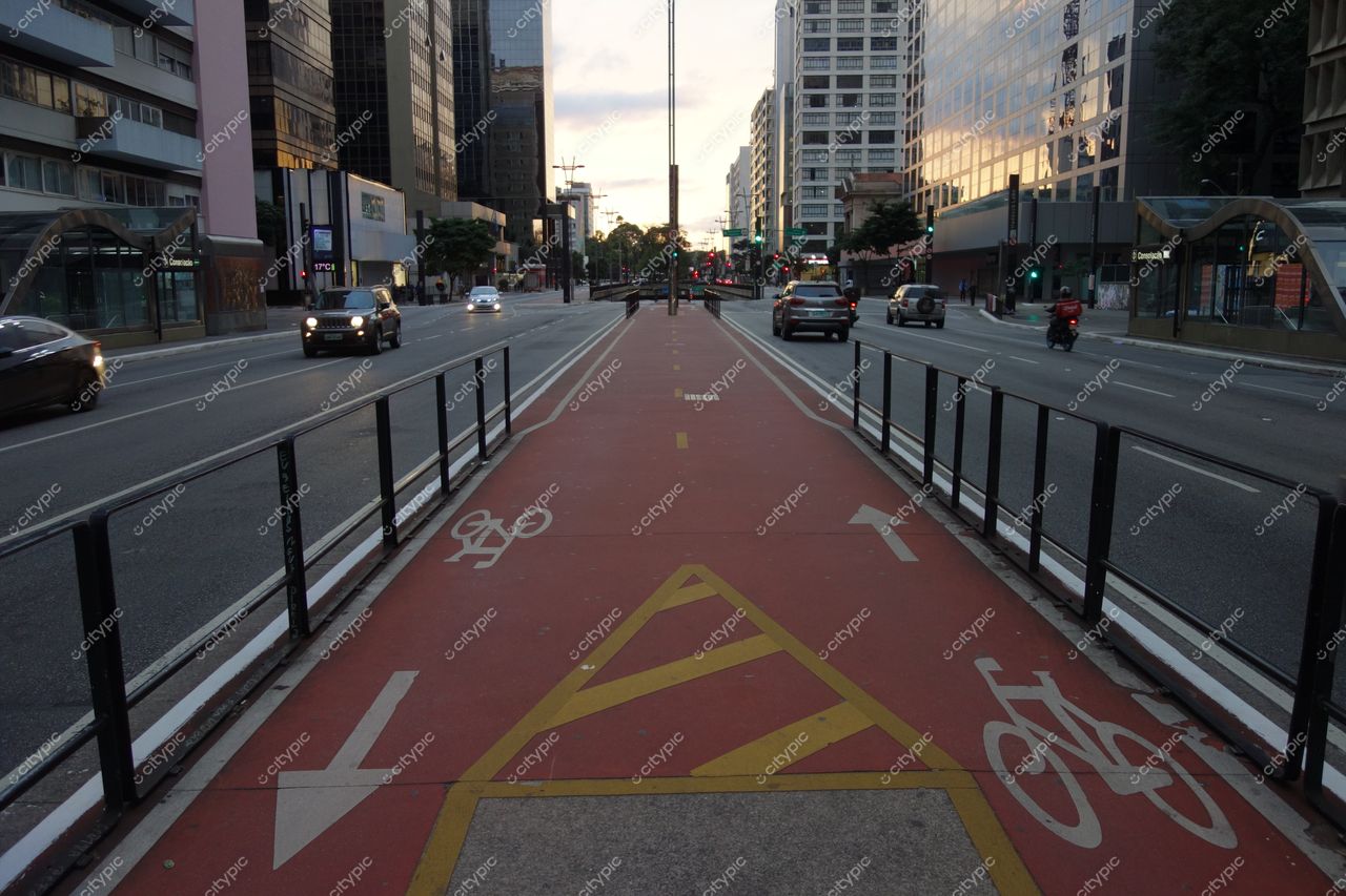 São Paulo, São Paulo, ciclovia ao entardecer entre arranha-céus com iluminação suave e tráfego urbano ativo