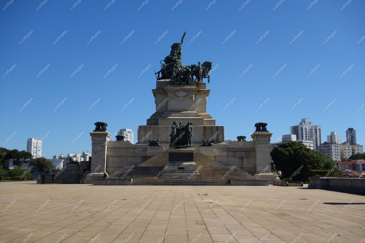 São Paulo, São Paulo, monumento histórico com esculturas sob céu azul e edifícios modernos ao fundo
