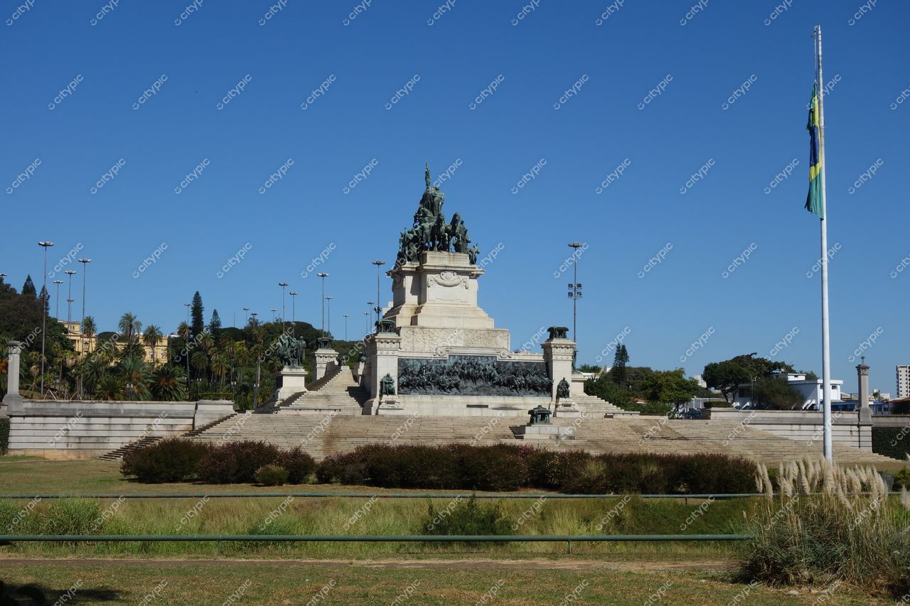 São Paulo, São Paulo, monumento imponente cercado por gramados e palmeiras sob céu azul claro em área urbana