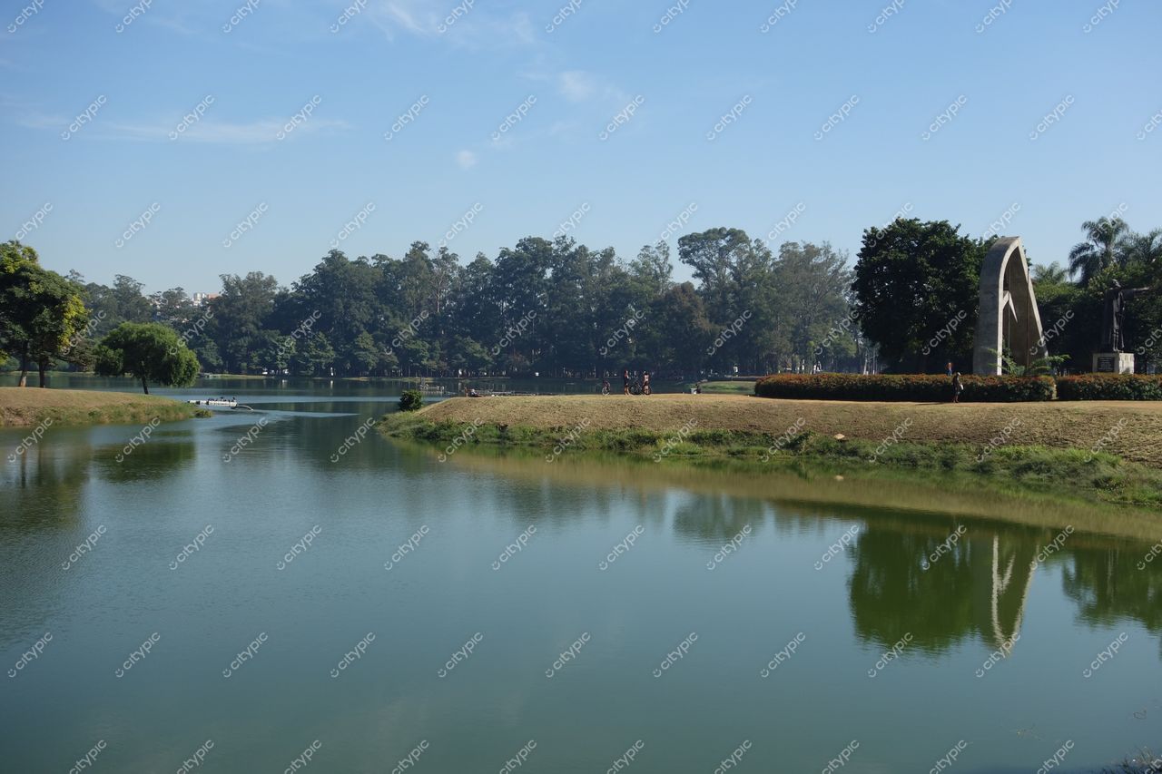 São Paulo, São Paulo Lago tranquilo no Parque da Água Branca com vegetação densa e arquitetura moderna ao fundo