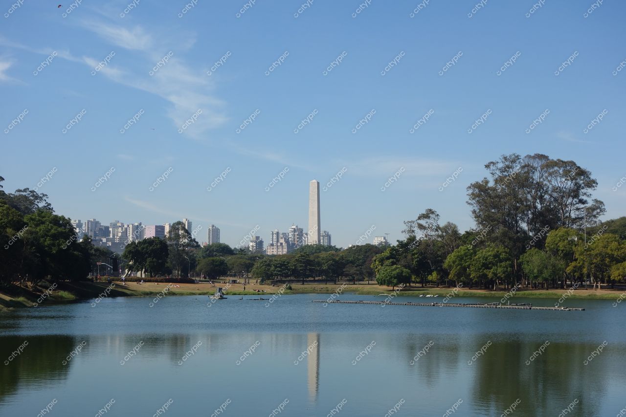 São Paulo, São Paulo, lago calmo refletindo edifícios sob céu azul com áreas verdes e árvores densas