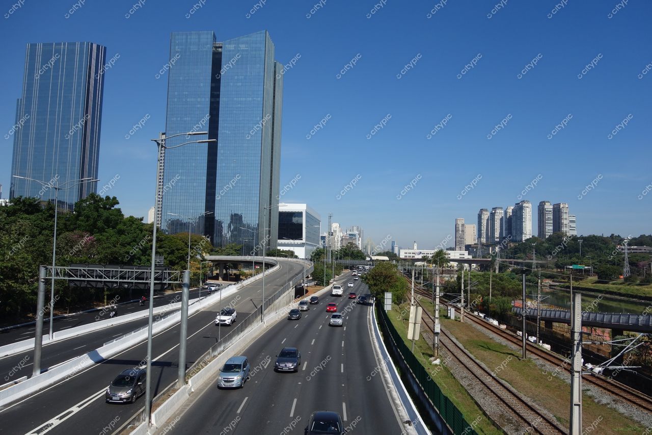 São Paulo, São Paulo, vista urbana com arranha-céus de vidro e vegetação sob céu azul em manhã ensolarada