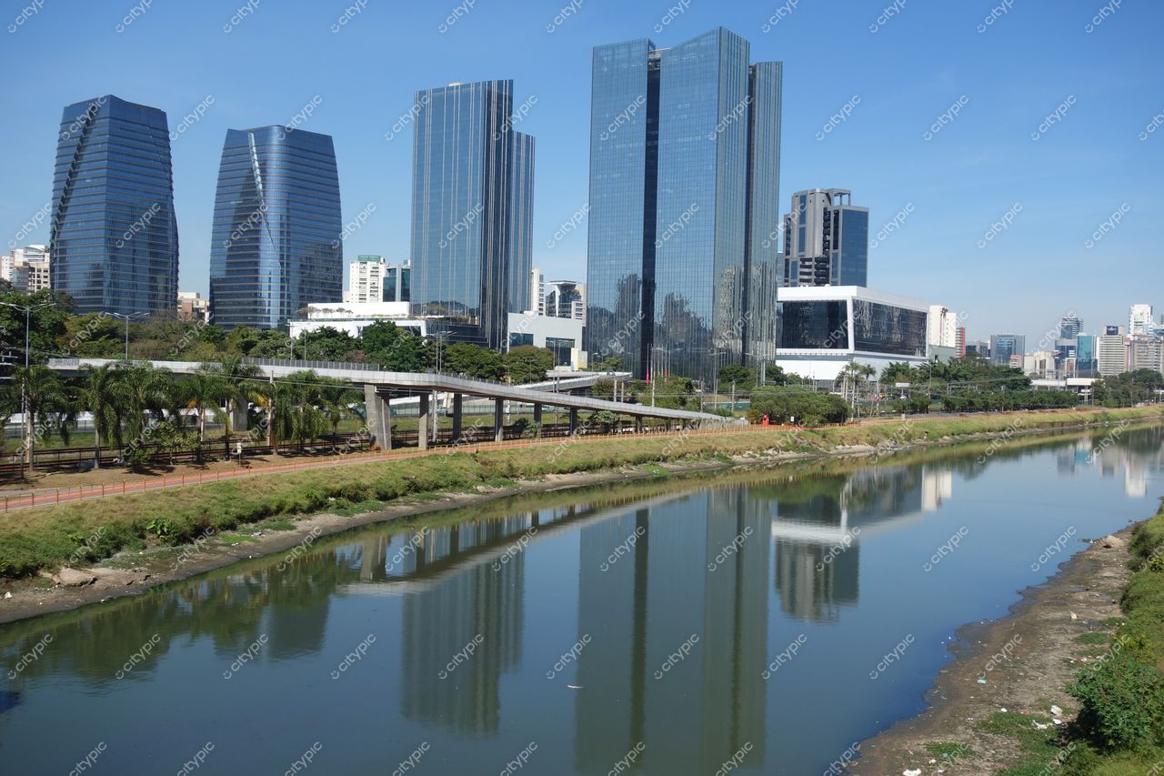 São Paulo, São Paulo, vista urbana com edifícios de vidro refletindo luz do sol e Rio Pinheiros em primeiro plano