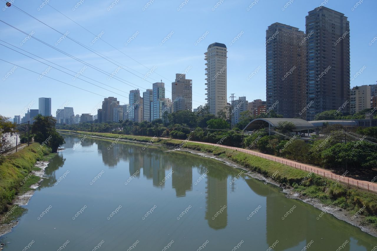 São Paulo, São Paulo, vista urbana em dia ensolarado com edifícios modernos e vegetação ao longo do rio