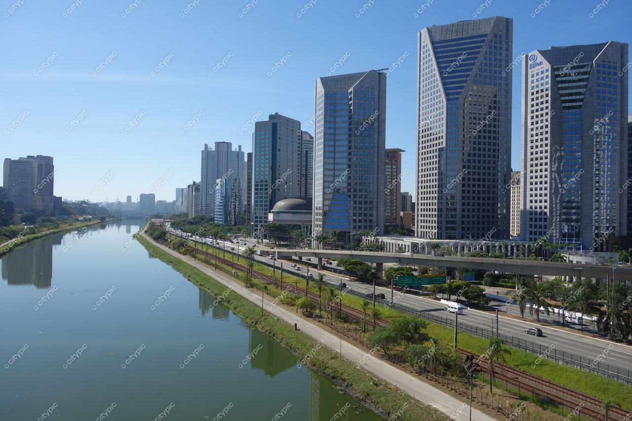 São Paulo, São Paulo, vista diurna com arranha-céus de vidro e viaduto sobre rio calmo e vegetação nas margens