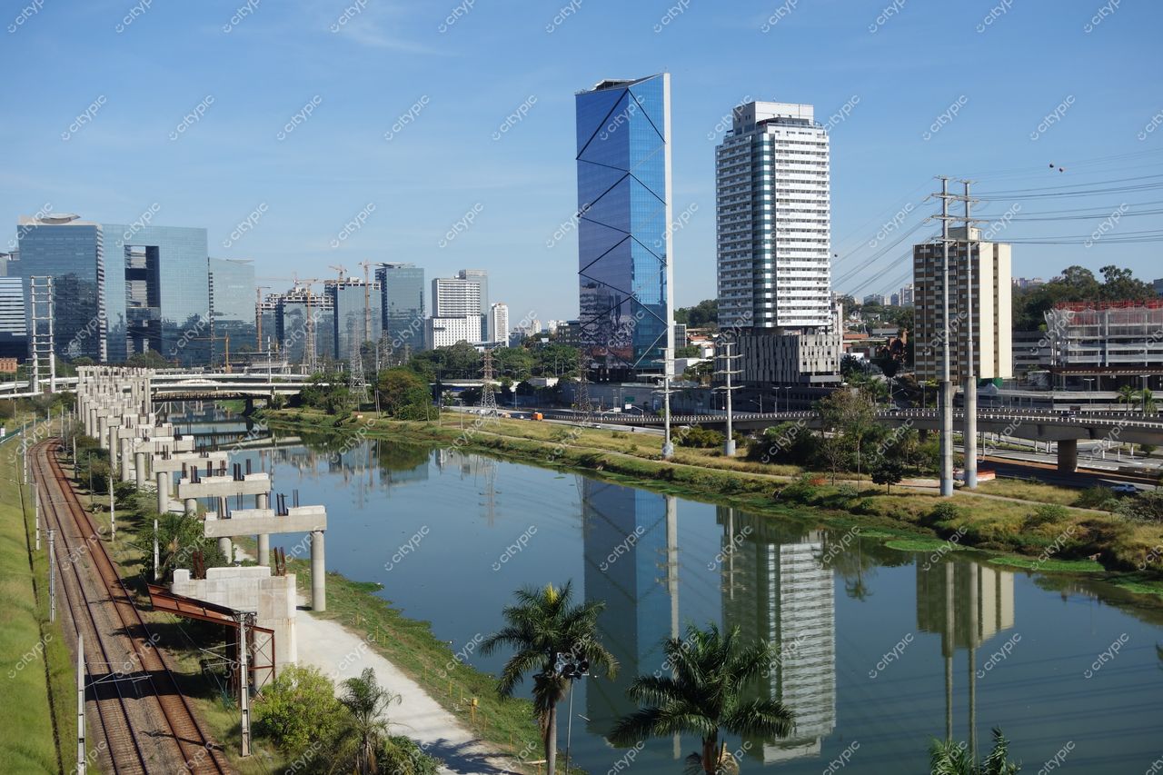 São Paulo, São Paulo, vista panorâmica em dia ensolarado com edifícios de vidro e vegetação ao longo do rio