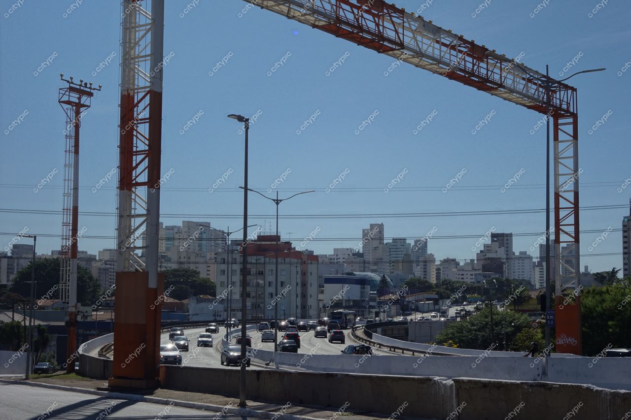 São Paulo, São Paulo, vista urbana com céu claro e ensolarado, tráfego intenso e vegetação nas laterais da via