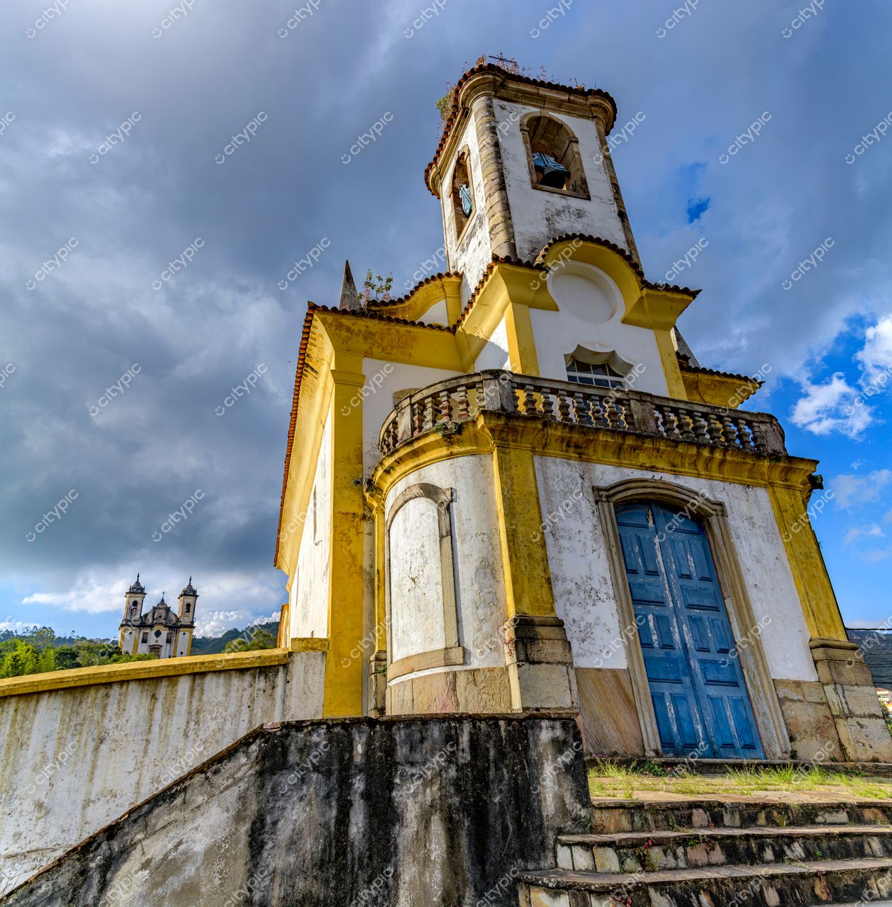 Igrejas Históricas de Ouro Preto em Ouro Preto com arquitetura colonial e detalhes em amarelo sob céu nublado e relevo acidentado