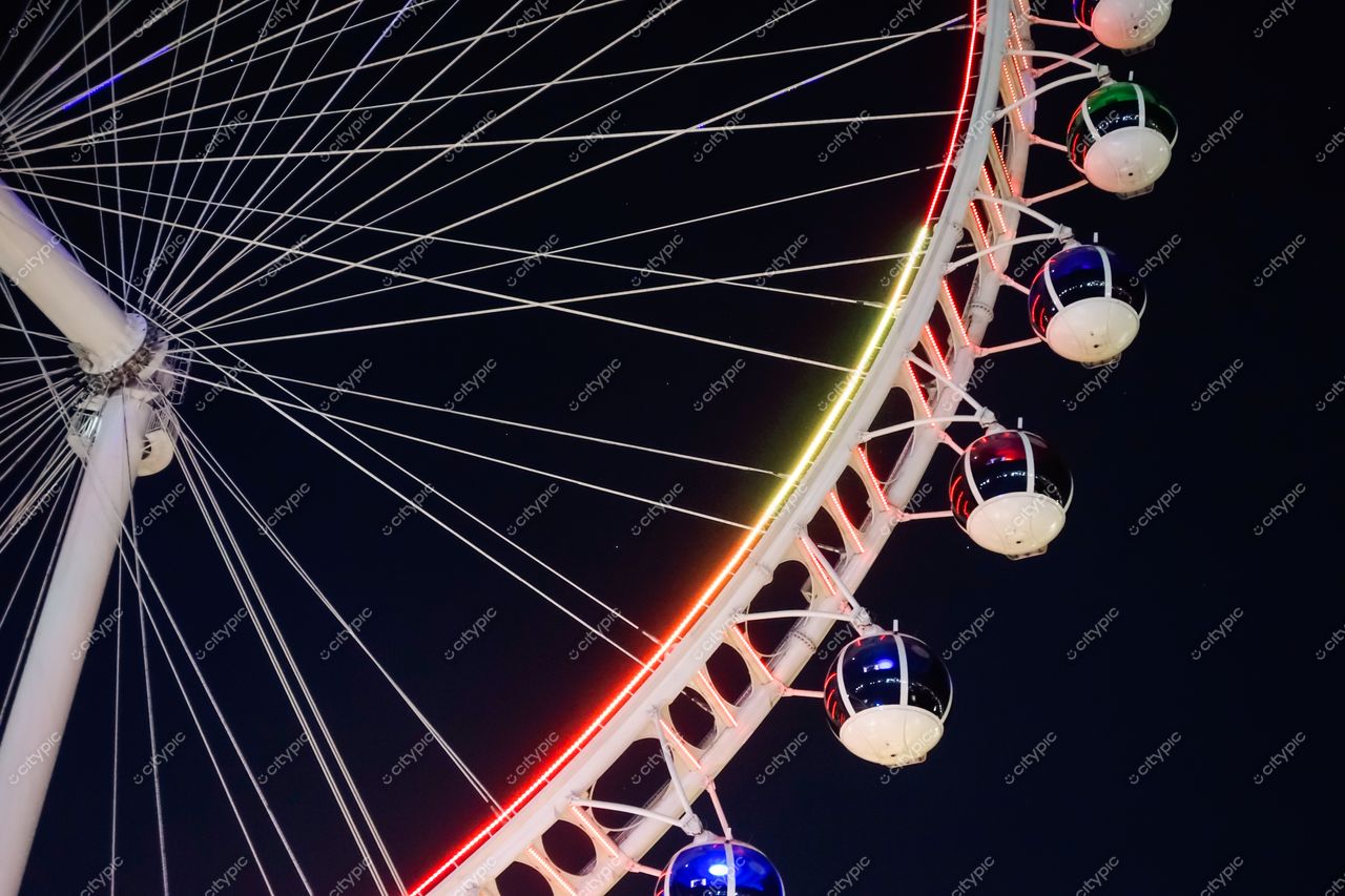 São Paulo, São Paulo, roda-gigante iluminada à noite com cabines coloridas e arquitetura moderna em fundo escuro
