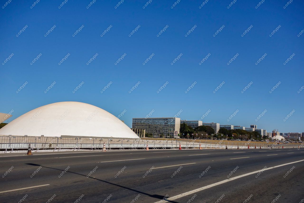 Esplanada dos Ministérios em Brasília com cúpula branca em dia ensolarado e edifícios de vidro ao fundo