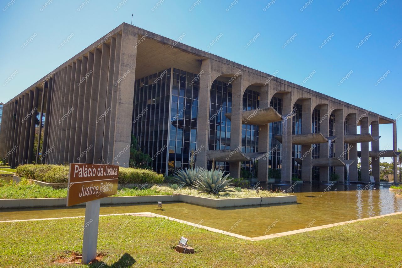 Palácio do Itamaraty, em Brasília, sob céu limpo e ensolarado com vegetação baixa e espelho d’água próximo