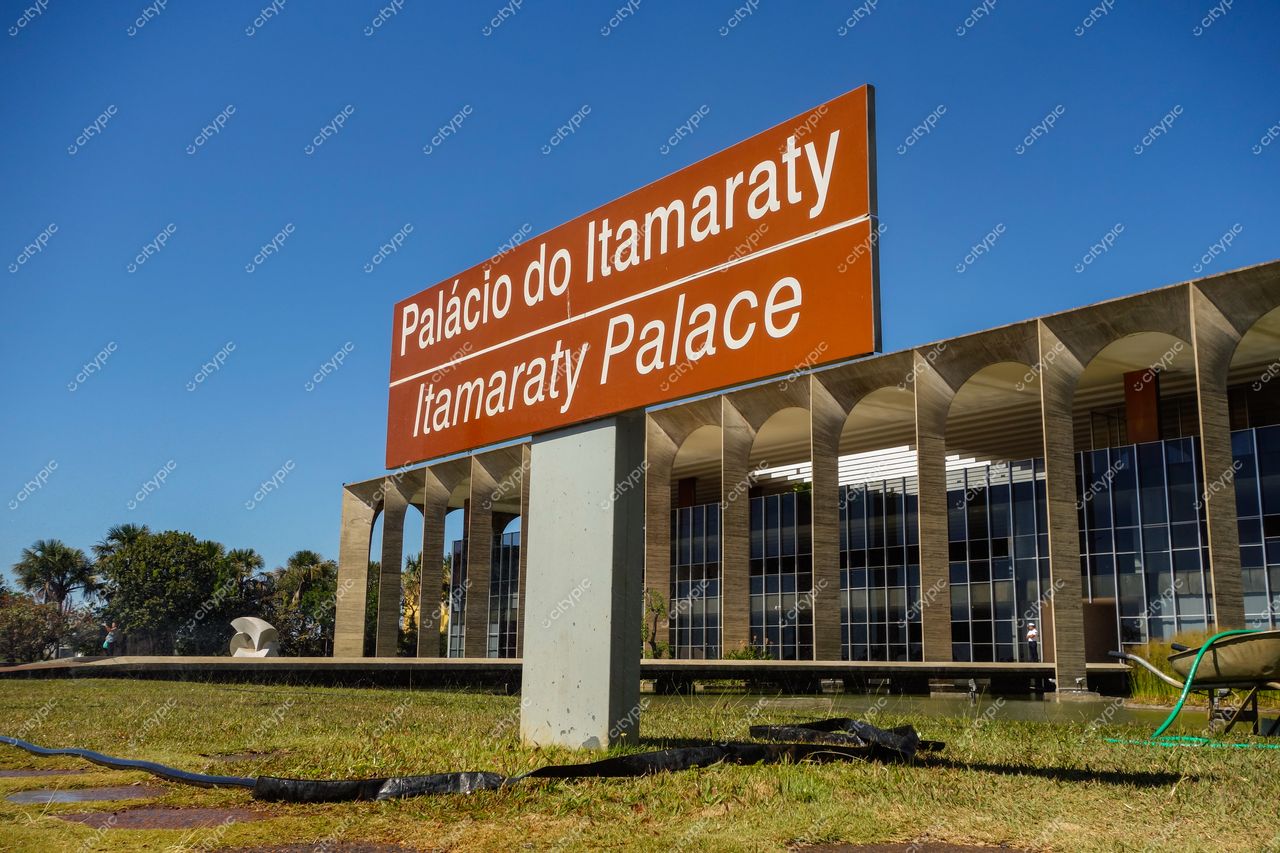 Palácio do Itamaraty, em Brasília, com fachada moderna e letreiro em destaque sob céu azul claro e vegetação cuidada